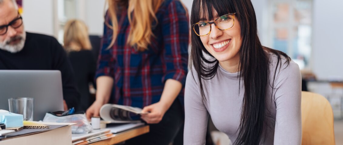 Frau sitzt auf einem Sessel mit Blick in die Kamera